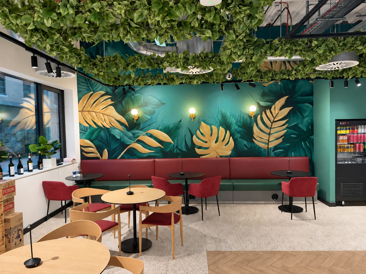Leafy ceilings, a colourful mural and red seating inside FORK Café Bar